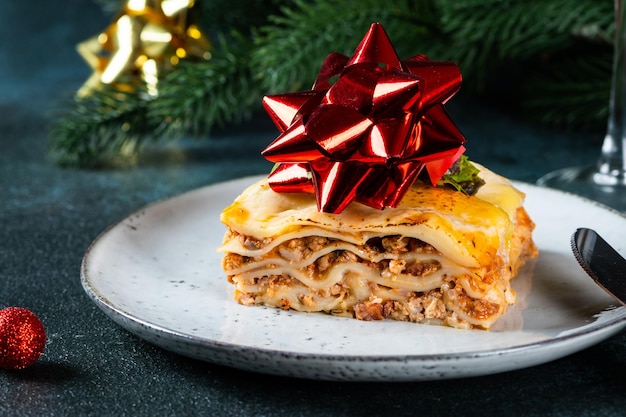 Pedazo de sabrosa lasaña caliente sobre fondo claro Lasaña italiana tradicional Comida italiana Cerrar lasaña Lasaña con decoración navideña Bodegón de comida Pasta casera