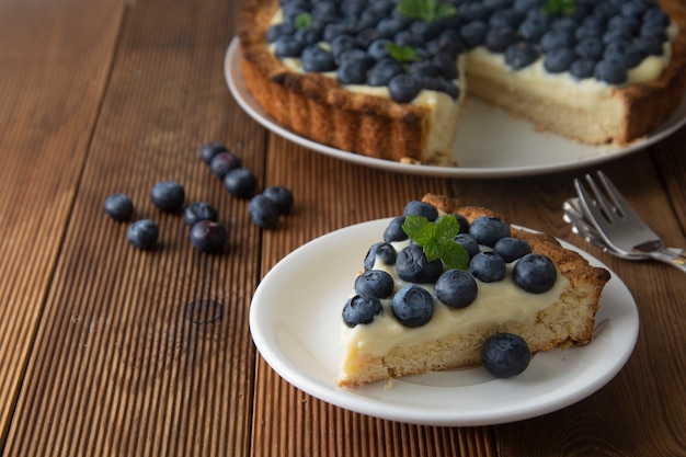 Pedazo de tarta de arándanos o pastel con crema. postre dulce fresco con frutas.