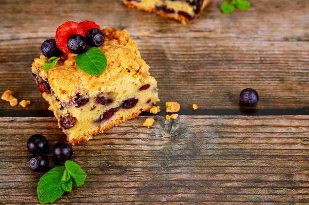 Pedazo de tarta de arándanos en superficie de madera