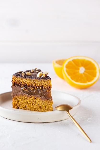 Pedazo de tarta de calabaza americana con naranja sobre un fondo claro. Azúcar, gluten, sin lactosa.