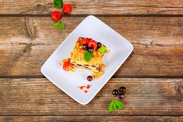 Pedazo de tarta casera de café de arándanos en un plato blanco sobre superficie de madera