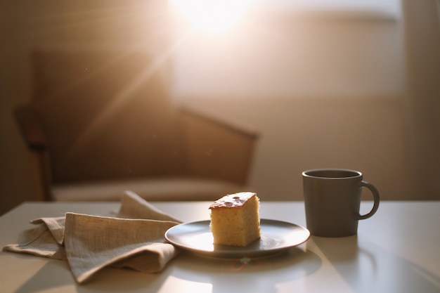 Pedazo de tarta casera fresca con taza de capuchino sobre una mesa