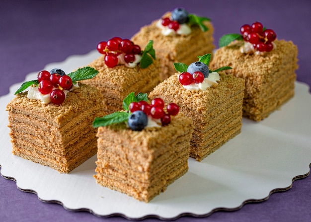 Pedazo de tarta de miel casera con frutos rojos frescos