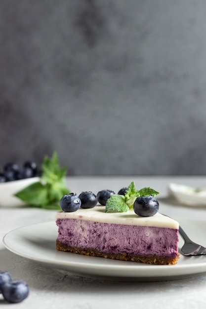 Foto pedazo de tarta de queso de arándanos, arándanos frescos y menta