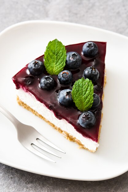 Pedazo de tarta de queso de arándanos en piedra gris