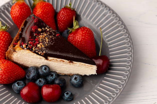 Pedazo de tarta de queso con chocolate y bayas