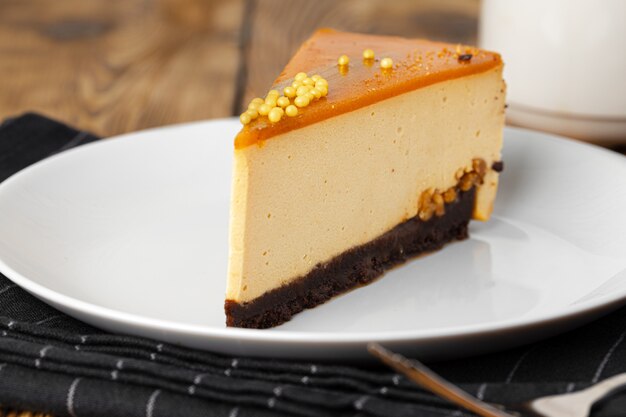 Pedazo de tarta de queso en un plato blanco sobre la mesa