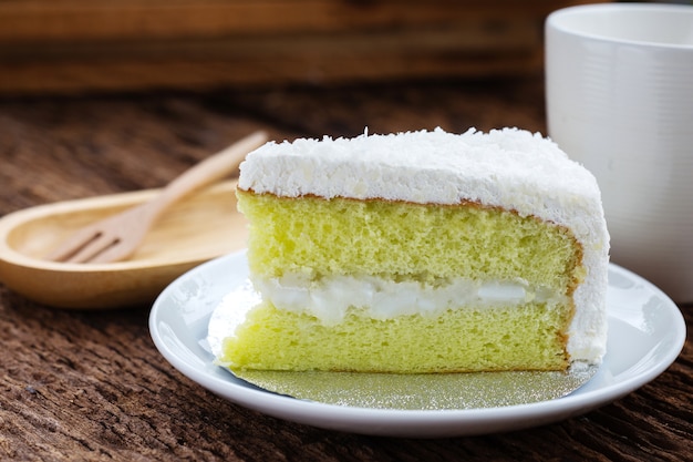 Pedazo de torta de coco de postre en el plato blanco.