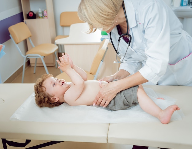 Pediatra amigável do doutor com criança paciente na clínica