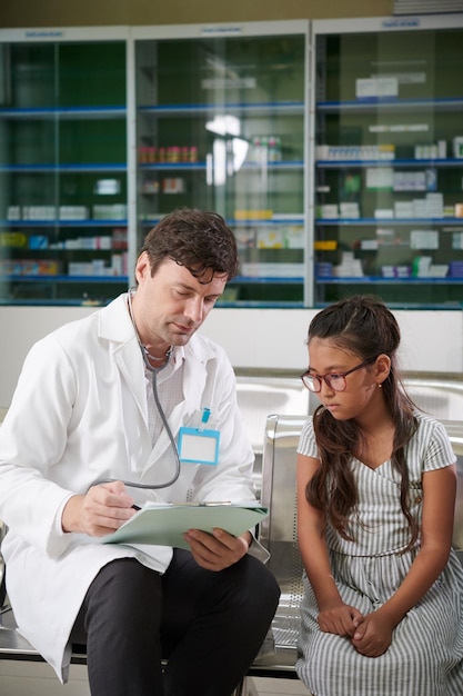 Pediatra conversando com menina pré-adolescente