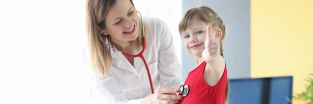 Pediatra escucha con estetoscopio al corazón de la niña. Concepto de tratamiento exitoso