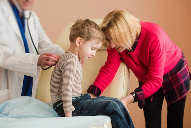 Pediatra escucha niño con estetoscopio
