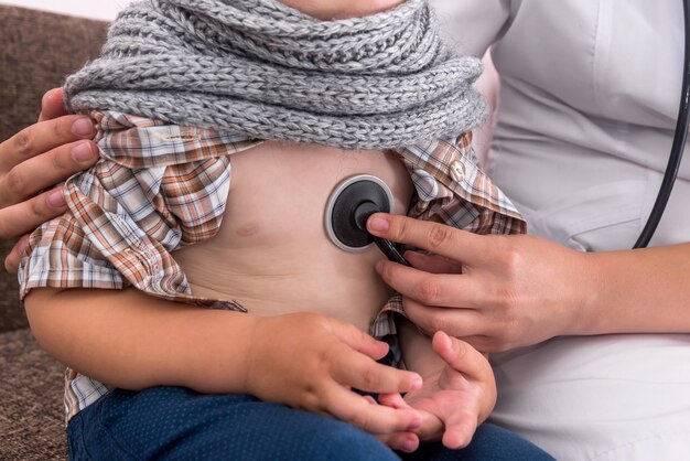 Pediatra escuchando los latidos del corazón del niño en el hospital