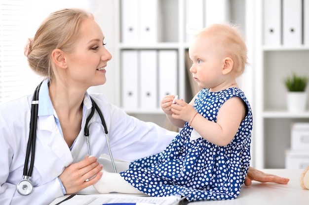 El pediatra está cuidando al bebé en el hospital. La niña está siendo examinada por un médico con estetoscopio. Concepto de atención médica, seguro y ayuda.