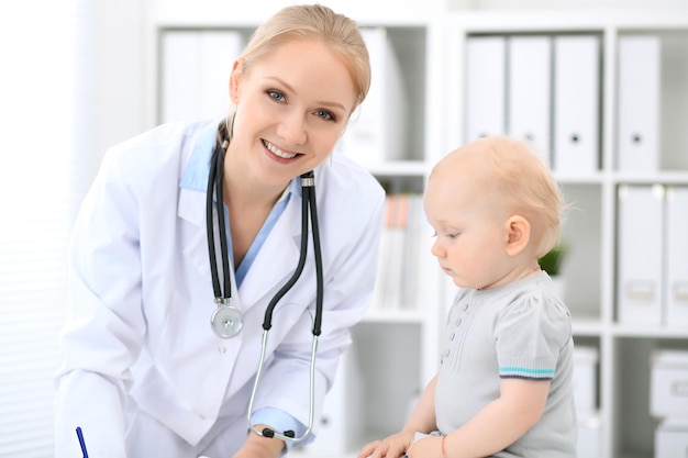 El pediatra está cuidando al bebé en el hospital. La niña está siendo examinada por un médico con estetoscopio. Concepto de atención médica, seguro y ayuda.