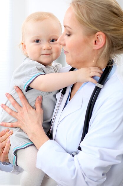 El pediatra está cuidando al bebé en el hospital La niña está siendo examinada por un médico con estetoscopio Concepto de ayuda y seguro de salud