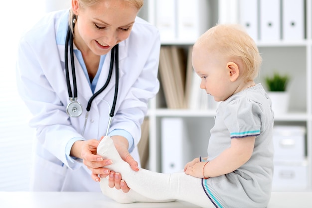 El pediatra está cuidando al bebé en el hospital La niña está siendo examinada por un médico con estetoscopio Concepto de ayuda y seguro de salud