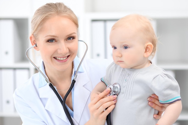 El pediatra está cuidando al bebé en el hospital La niña está siendo examinada por un médico con estetoscopio