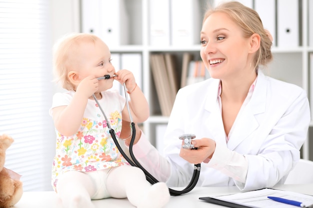 El pediatra está cuidando al bebé en el hospital La niña está siendo examinada por un médico con estetoscopio