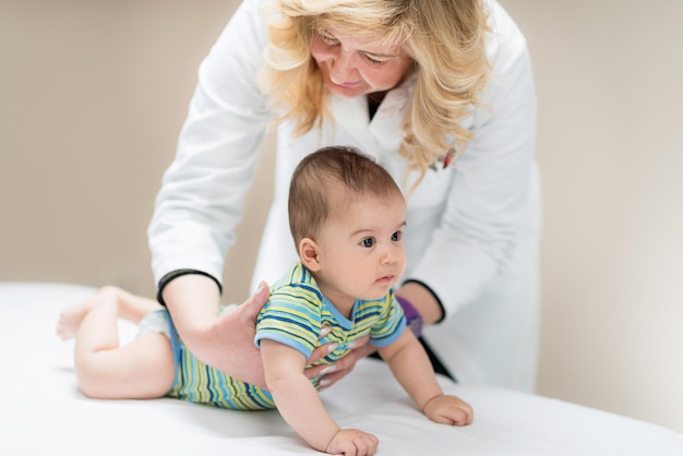 El pediatra examinando a un bebé lindo