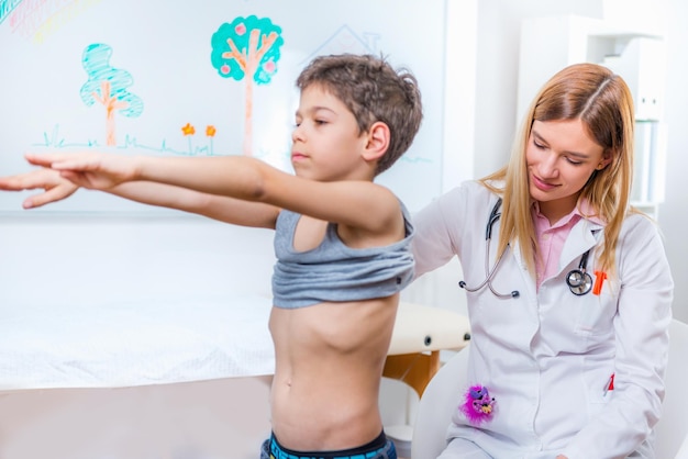 Pediatra examinando la columna vertebral del niño