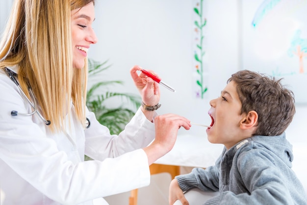 Pediatra examinando la garganta del niño