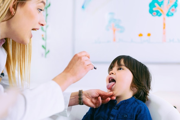 Pediatra examinando la garganta del niño