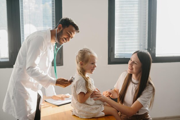 Foto un pediatra examinando a una niña con un estetoscopio