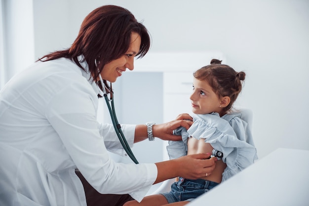 Pediatra con experiencia trabaja con niña en la clínica.