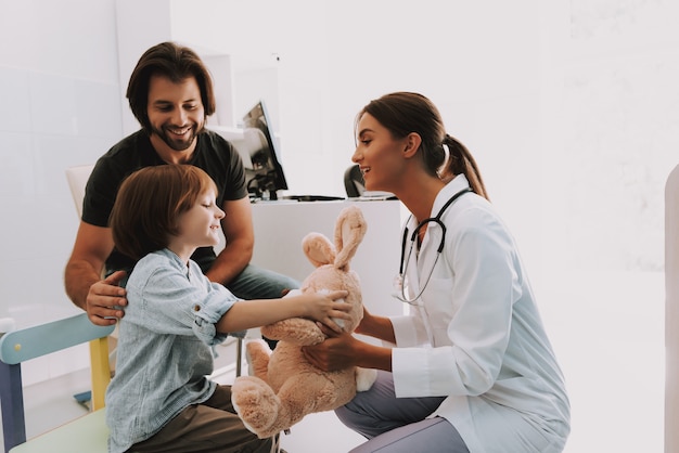 Pediatra feminina dá brinquedo de coelho para criança