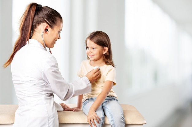 Pediatra masculino segurar estetoscópio exame criança menino paciente visitar médico com a mãe,