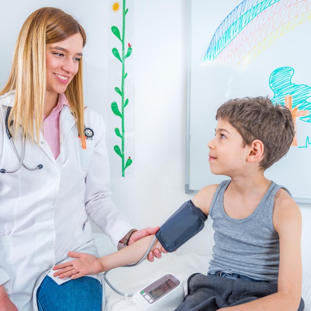 Pediatra midiendo la presión arterial del niño