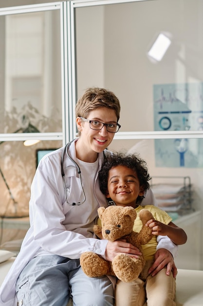 Pediatra con pequeño paciente en el consultorio