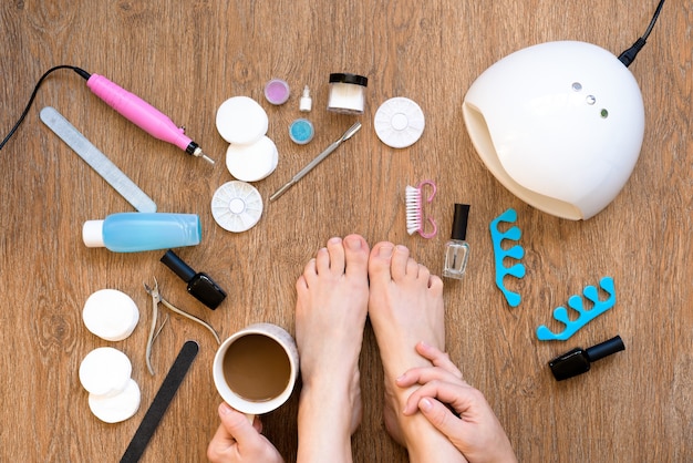 Pedicura en casa con esmalte de uñas y lámparas UV, limas y tijeras.