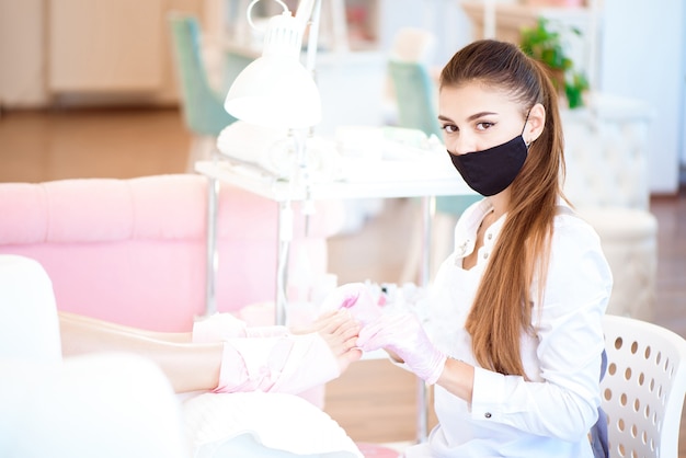 Pedicura en salón de belleza. Pulido de uñas con esmalte de uñas. De cerca.