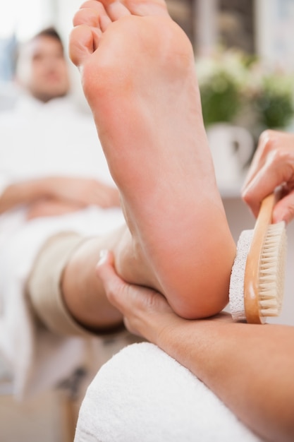 Pedicurist, der Kundenfuß massiert