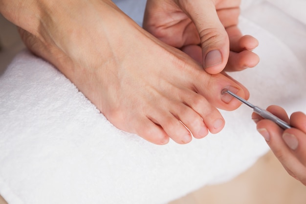 Pedicurist, der Kundenzehenägel säubert