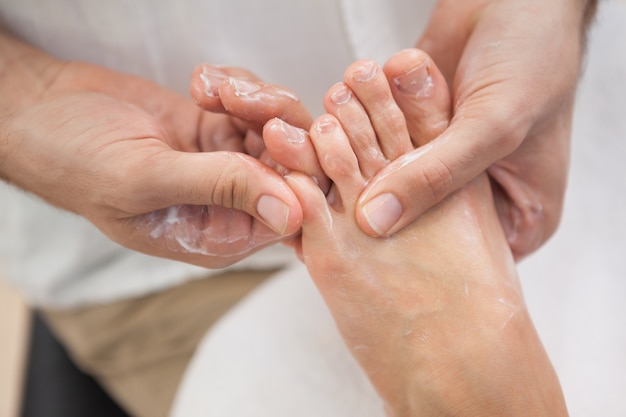 Pedicurista dando masajes al pie de los clientes