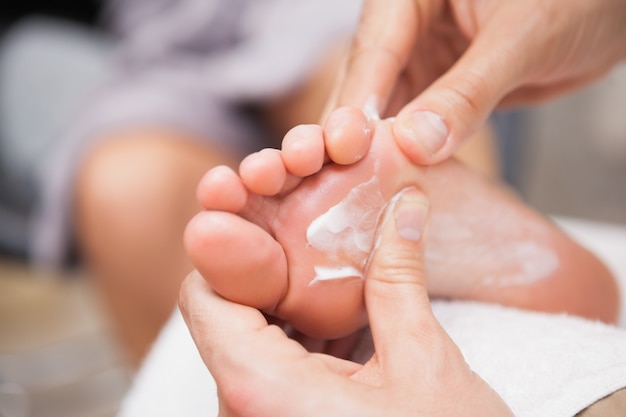 Pedicurista masajeando el pie de un cliente