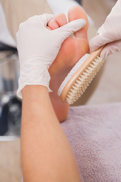 Pedicurista trabajando en los pies de los clientes