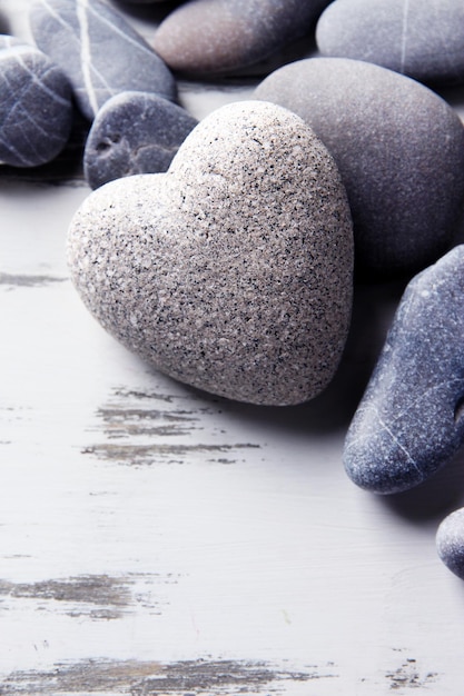 Pedra cinza em forma de coração na cor de fundo de madeira