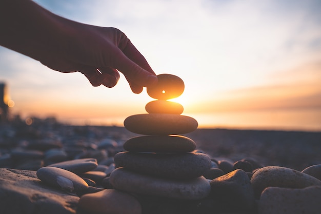 Pedra com um buraco ao pôr do sol. Encontre um talismã e faça um pedido