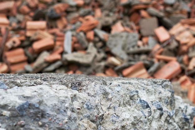 Pedra de concreto cinza com tijolos vermelhos quebrados no fundo como ruínas do cenário de construção