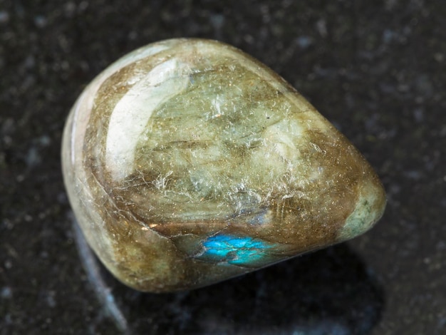 Pedra de gema de labradorita polida em fundo escuro