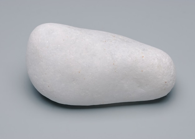 Foto pedra de massagem quente relaxante isolada em fundo neutro.