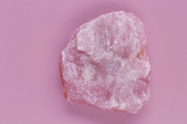 Pedra de quartzo rosa close-up sobre uma superfície rosa. Amuleto do amor