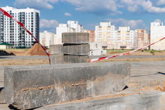 Pedra do meio-fio de concreto na estrada com superfície de estrada esburacada. Trabalho de reparação de estradas. Instalação de uma nova pedra de meio-fio antes da colocação do novo asfalto.