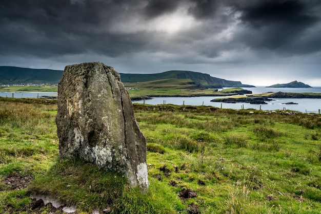 Pedra em pé na costa da Ilha Valentia em Kerry, Irlanda