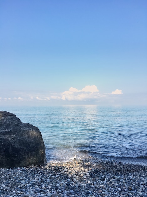 Pedra enorme em uma praia de calhau