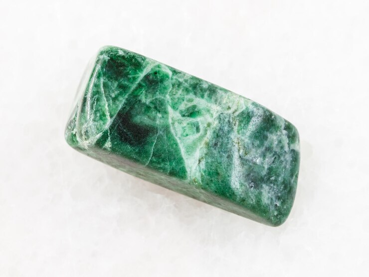 Foto pedra jadeíta verde caída em mármore branco
